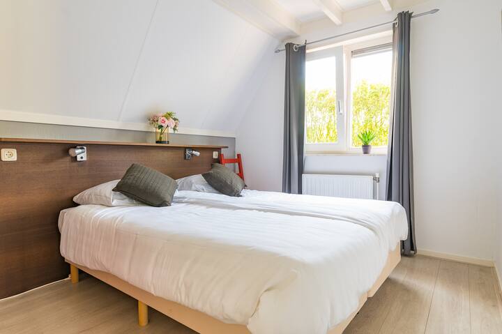 Bedroom on the ground floor with 2 box springs that can be placed separately from each other if necessary. 
For clothes there is a dresser and there is a TV in the bedroom.