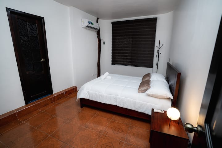 Quarto principal com cama de casal, casa de banho separada, armário grande e ar condicionado