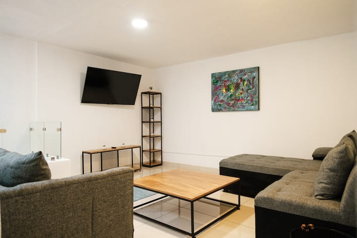 Sumérgete en el confort de nuestra amplia sala de TV con una Smart TV de 60 pulgadas. El espacio perfecto para relajarte, descansar y disfrutar de películas con estilo y comodidad.