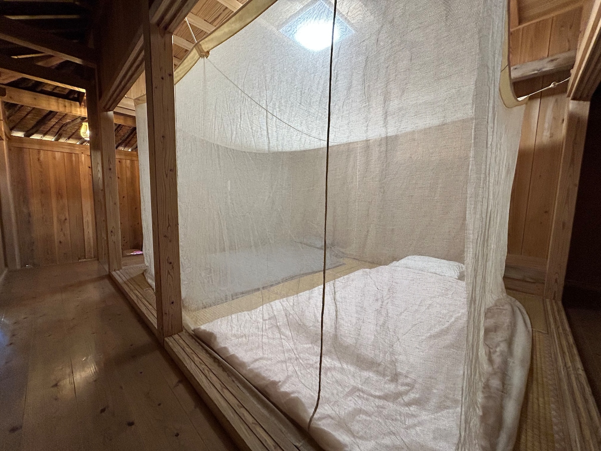 Спане на диван в мрежа против комари就寝は蚊帳の中で