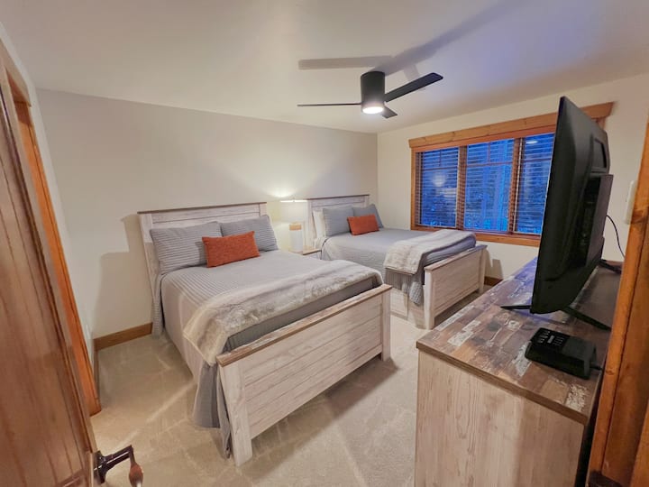 Dormitorio 1 con dos camas dobles en el piso principal. Tiene su propio baño de tamaño completo compartido con el espacio común. 