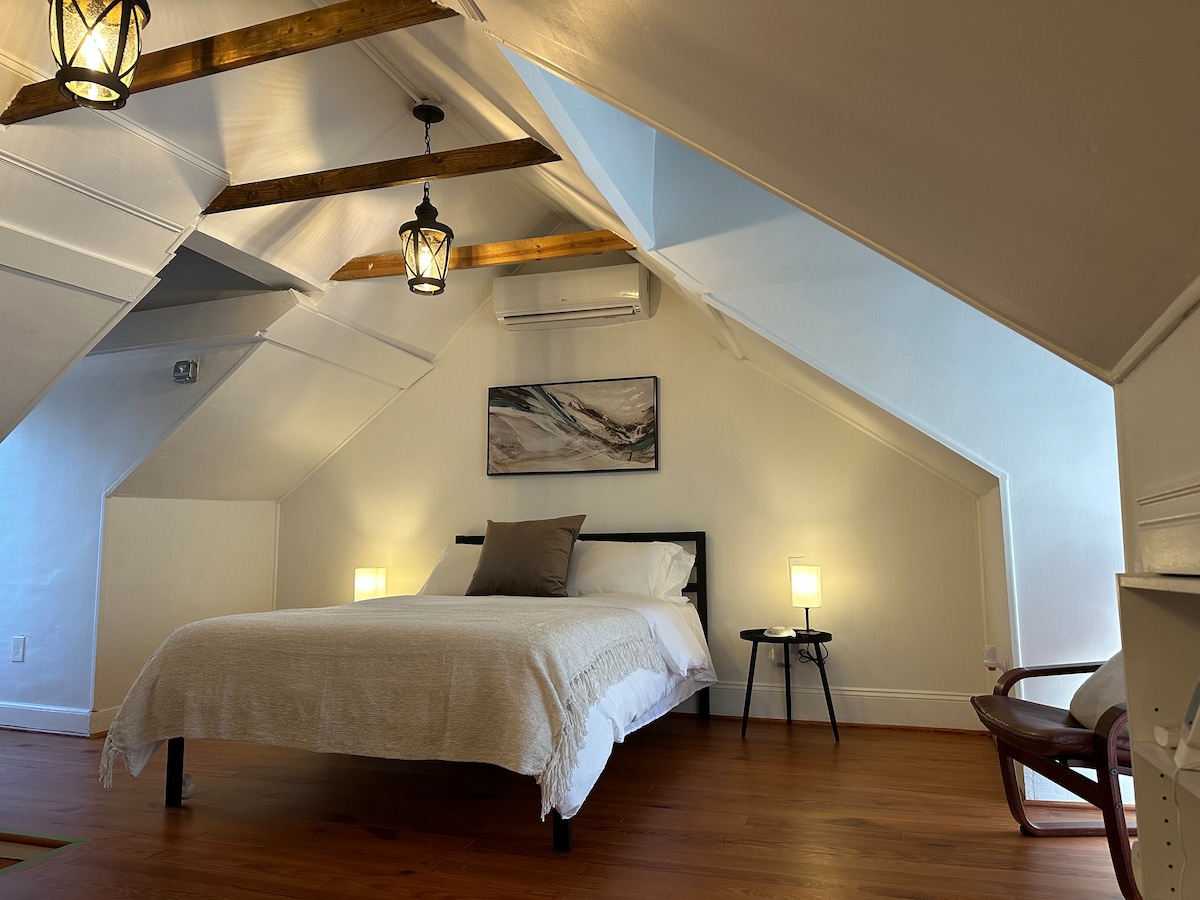 Lit queen size dans un loft, parquet en pin