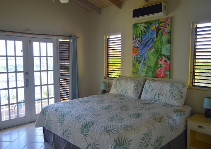 Dormitorio principal con cama tamaño king y aire acondicionado.