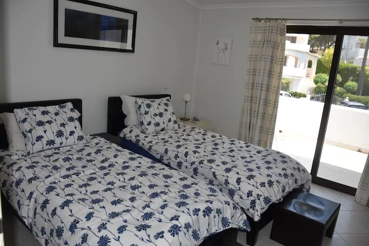 Spálňa s oddelenými posteľami na poschodí s veľkým balkónom a vlastnou kúpeľňou so sprchovacím kútom.