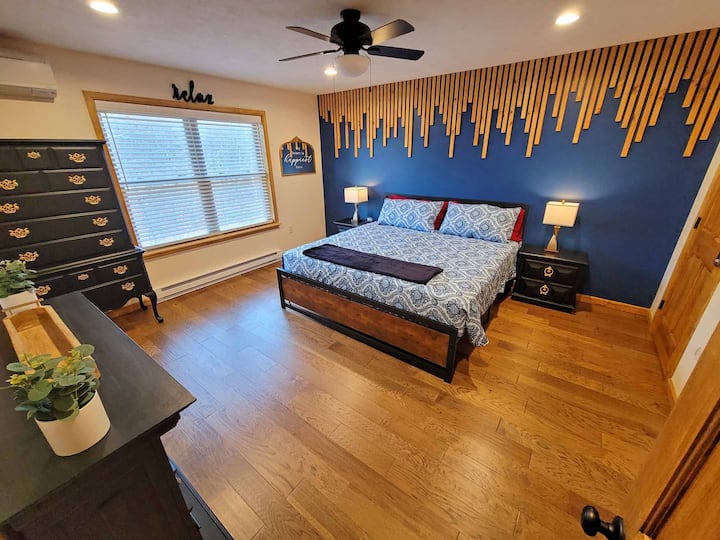 Chumba Maalumu cha kulala kina joto, kinavutia na kina vipande vya samani vyenye ujasiri, meko yenye starehe na kitanda kikubwa.