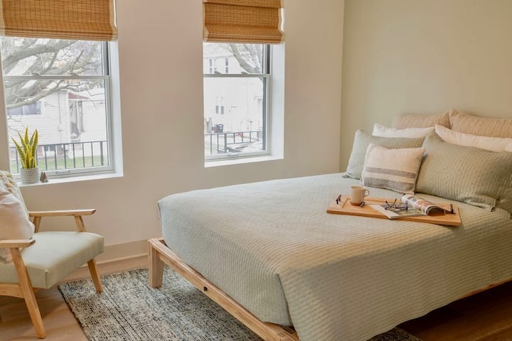 Peaceful bedroom with queen size bed on a beautiful Thuma frame and Dreamcloud mattress.  There are room darkening shades on the two eastern facing windows.