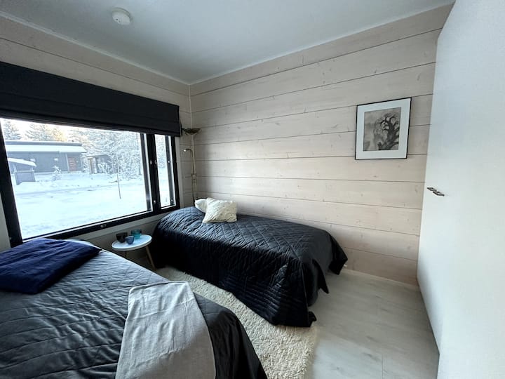 Makuuhuone kahdella sängyllä ja vaatekaapilla. 