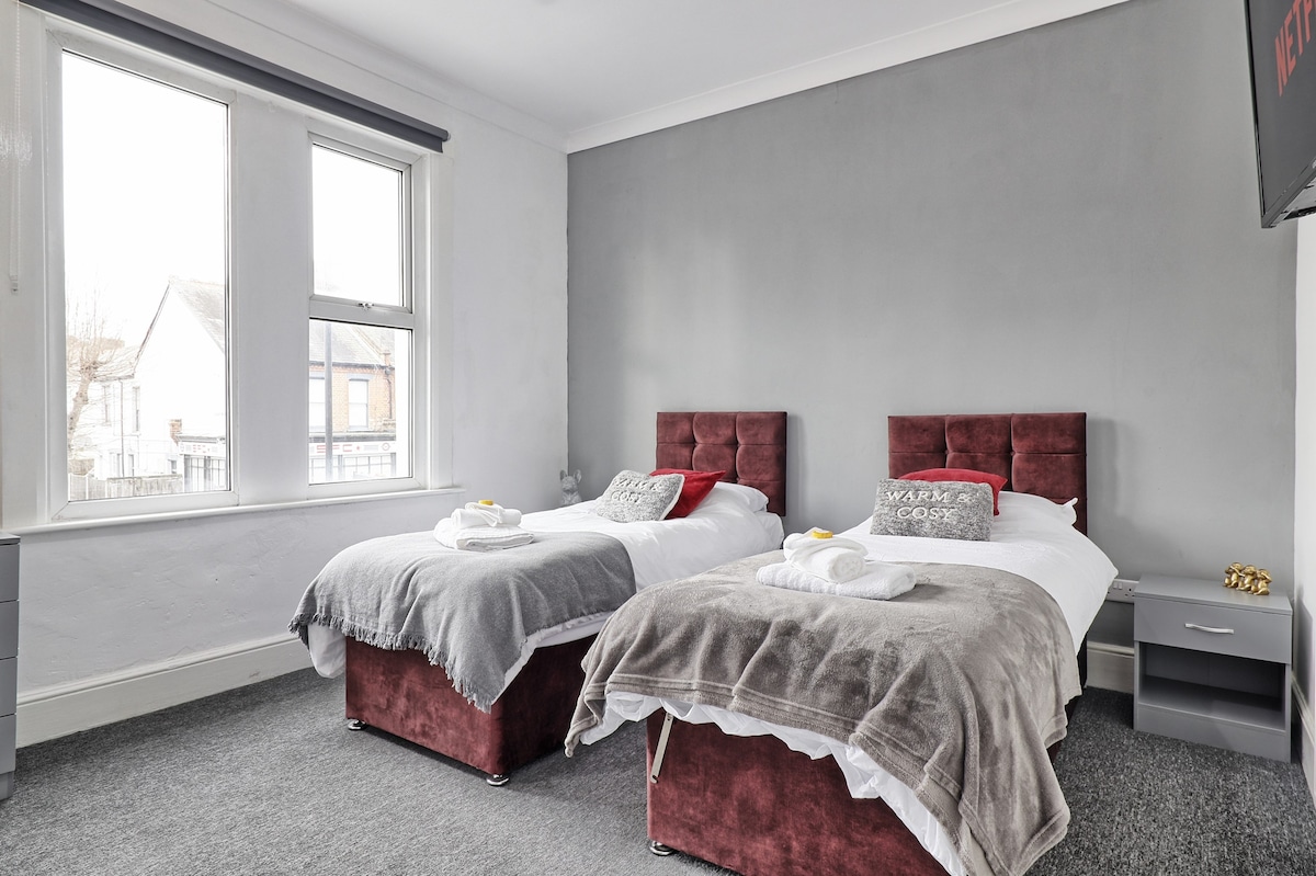 前卧室配有舒适的红色双人床和一台可收看Netflix的平板电视。