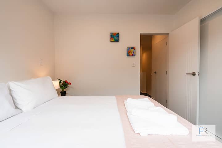 Dormitorio tamaño queen con persianas y armario.