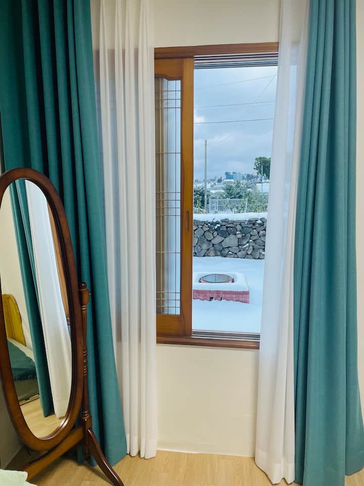 Un día nevado, una vista al patio desde una habitación pequeña