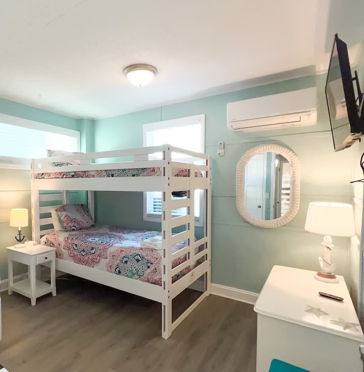 Bedroom 5 Downstairs: Equipped with a twin bunk bed, wifi tv, dresser, and nightstand.