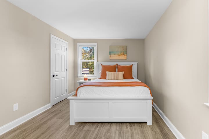 חדר שינה ראשי עם מיטת קווין סייז וחדר רחצה צמוד.