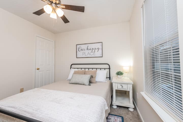 ห้องนอนสำหรับผู้เข้าพักพร้อมพัดลมเพดานและโต๊ะข้าง