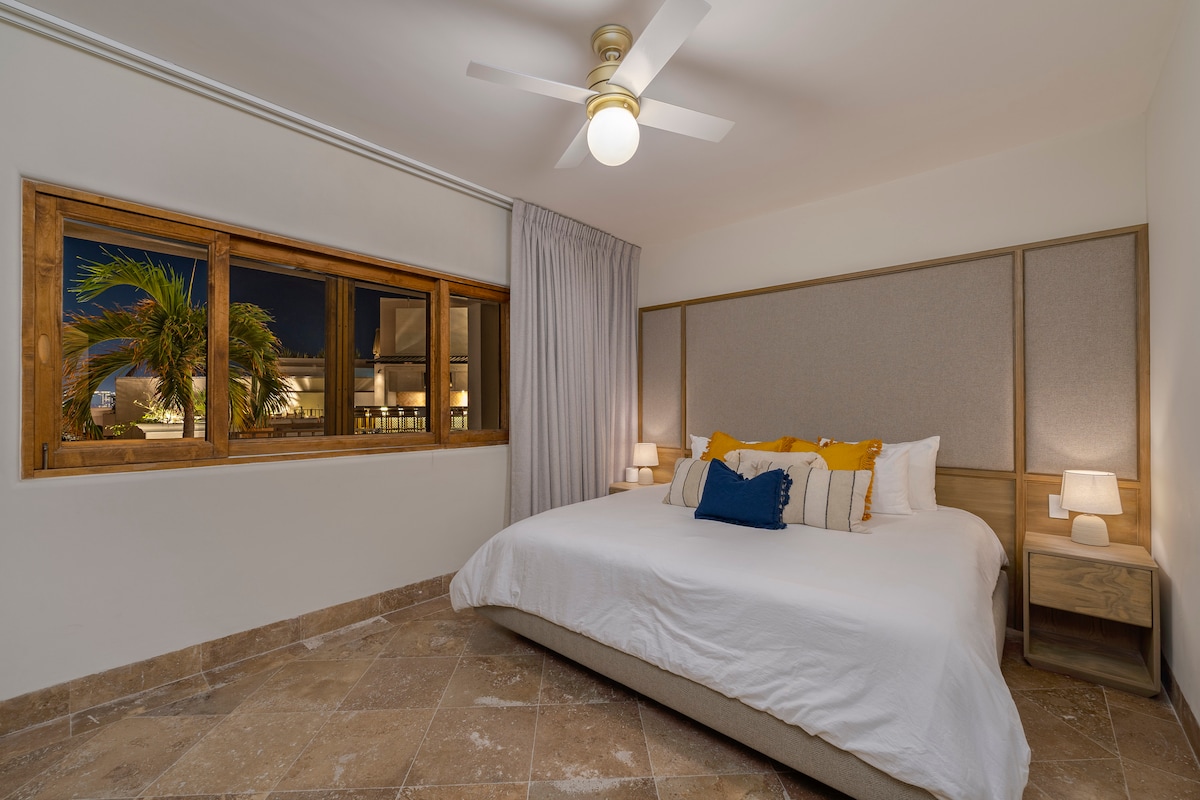 Debajo de la sala de estar principal bajando las escaleras junto a la cocina, encontrarás un cuarto dormitorio con una hermosa ventana con vistas al área de la piscina. 