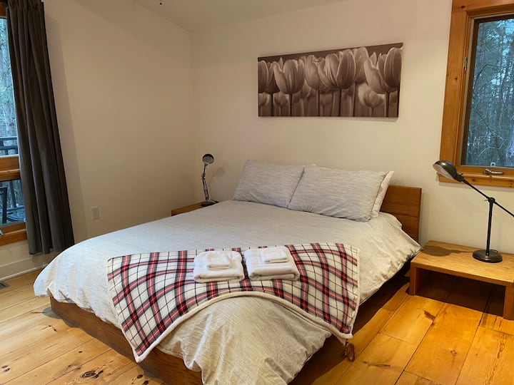 Letto queen-size in camera da letto matrimoniale con bagno interno completo, al piano principale.