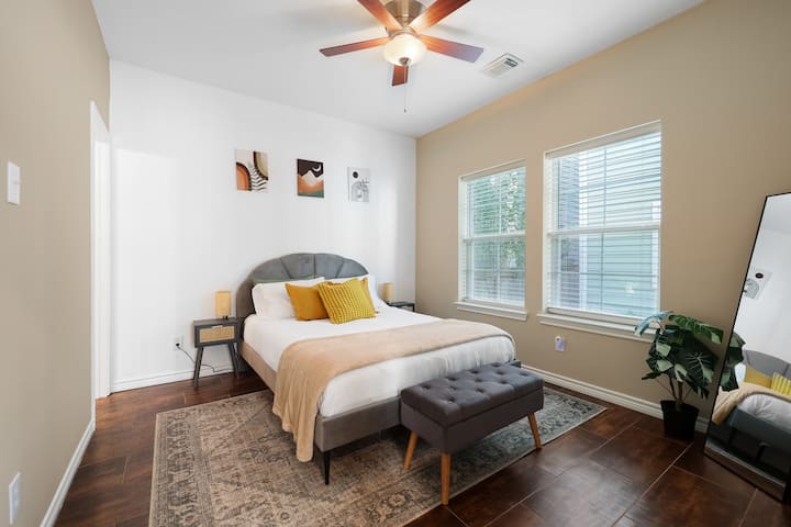 Slaapkamer op de eerste verdieping met een queensize bed, inloopkast en toegang tot een eigen badkamer.