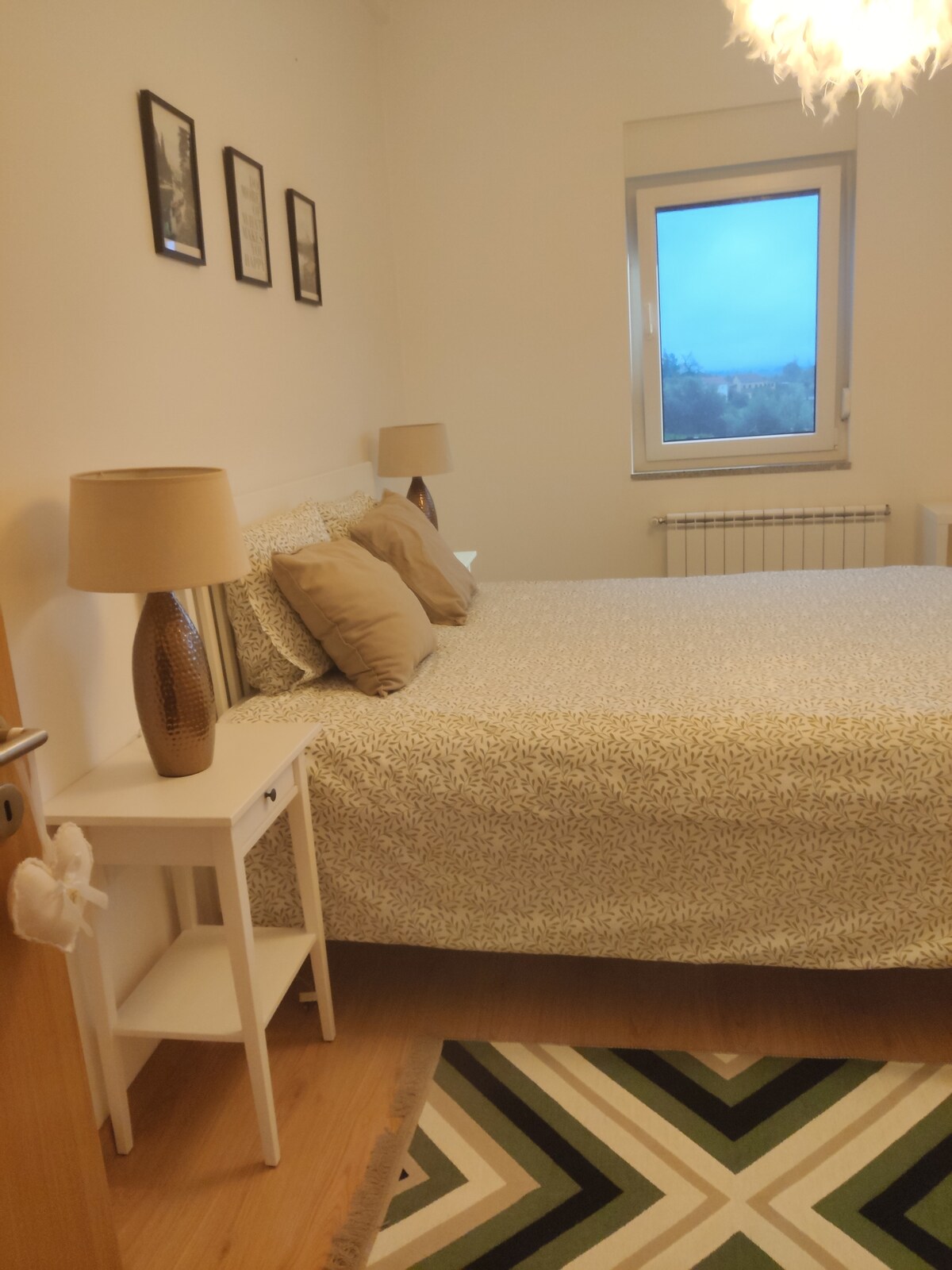 Dormitorio con calefacción central y una cama doble.