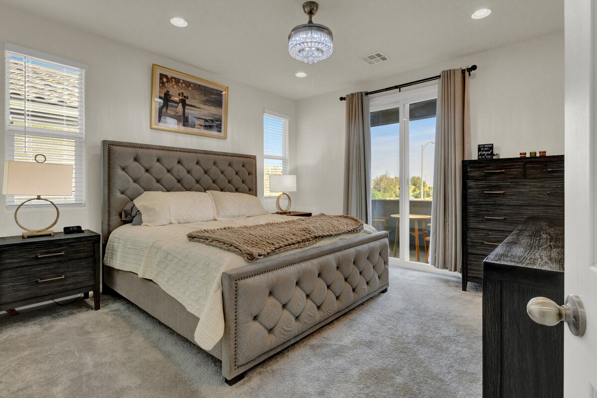 חדר שינה ראשי עם מיטת קינג סייז מועשר באור טבעי.