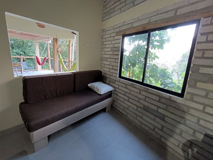 De woonkamer-slaapkamer heeft twee eenpersoons slaapbanken, met klamboes. Het is open naar de woon-eetkamer en heeft een tweede badkamer vlakbij.