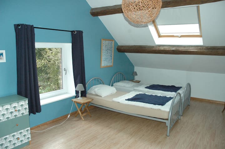 Chambre du 2è étage avec trois lits simples et un lavabo. Espace pour mettre le lit parapluie à votre disposition.