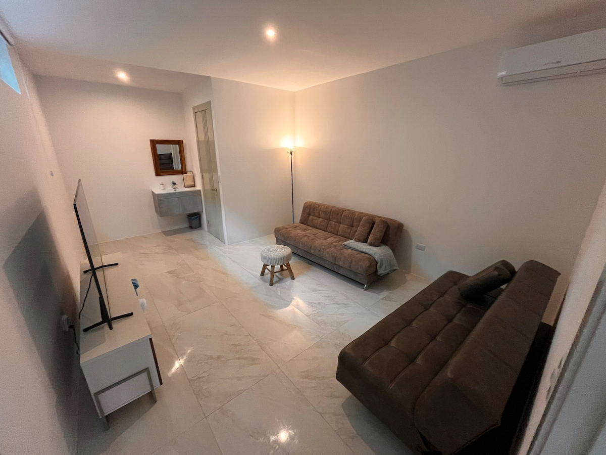 ห้องนอนที่ห้าในชั้นแรกพร้อมทีวีและเตียงโซฟา 2 หลังสำหรับ 1 พื้นที่พร้อมห้องน้ำส่วนตัว