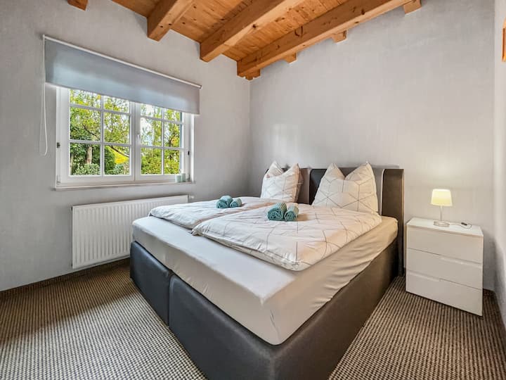 Lassen Sie sich nach einem ereignisreichen Tag in ein großes gemütliches Boxspringbett im ersten Schlafzimmer fallen.