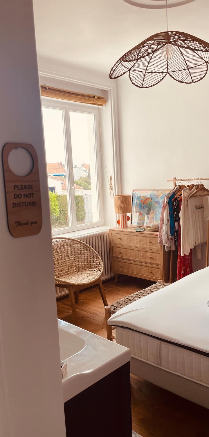 Chambre 2 : Suite parentale sur parquet, Lit 160x200, baignoire sur pied et meuble lavabo, commode, portant, fauteuil, 2 tables de nuit