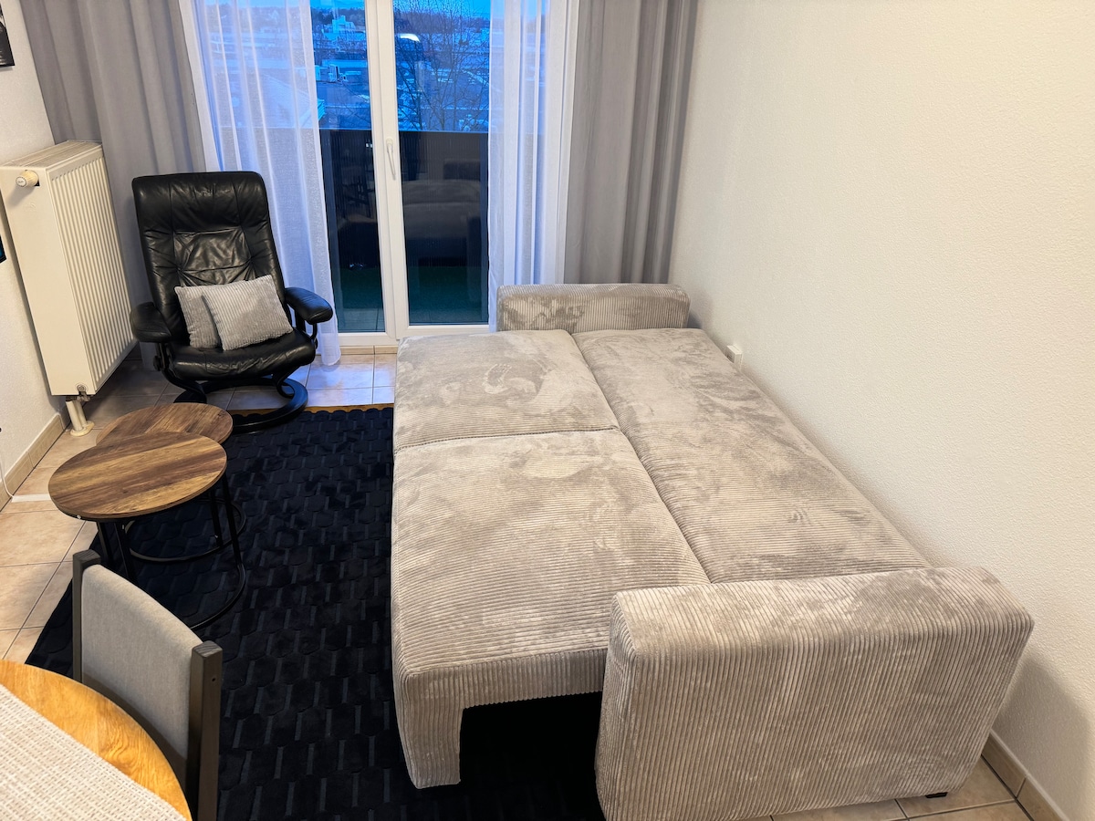 Pohodlná rozkladacia pohovka v otvorenej polohe, príprava na vytvorenie útulnej postele v obývacej izbe. 