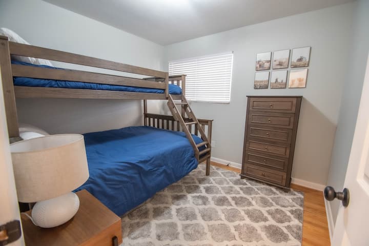 Dormitorio con una litera inferior tamaño queen y una litera superior doble XL (longitud para adultos).