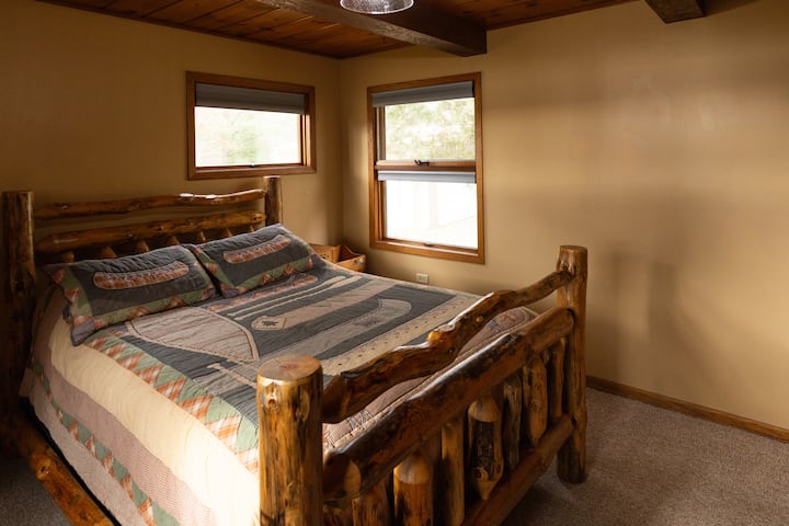 Este es el dormitorio principal con una cama tamaño queen. Hay persianas inalámbricas hacia abajo.