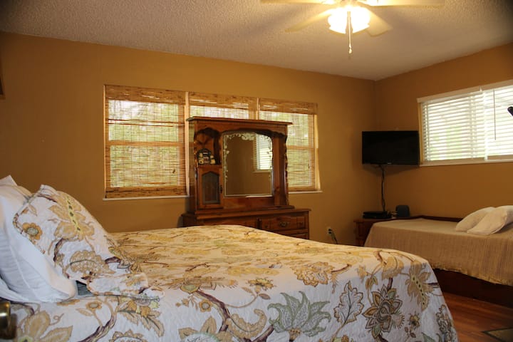 غرفة نوم ثانية بسرير كينج وسرير مزدوج وتلفزيون وحمام داخلي.