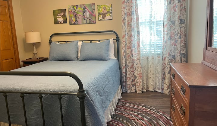 Queen bed with antique dresser and chair.  Full closet has extra linens, fan, and plenty of storage for clothes.
