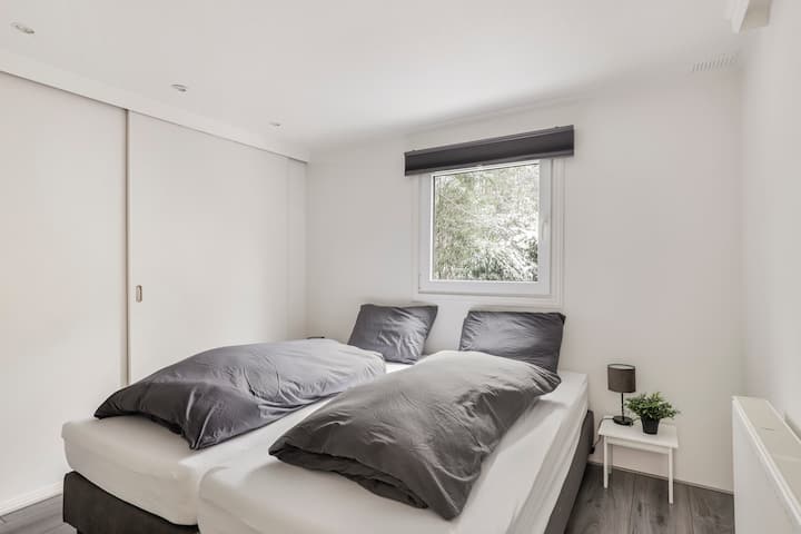 Chumba kikubwa cha kulala kilicho na chemchemi ya visanduku viwili na nafasi ya kutosha ya kuhifadhi kwenye ukuta wa wodi.