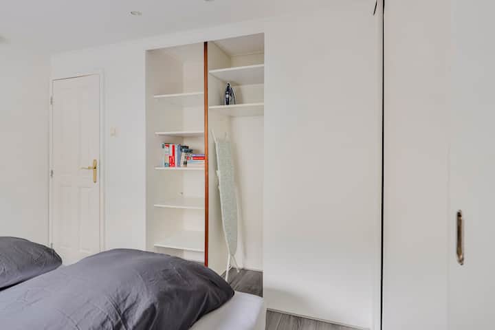 Chumba cha kulala chenye nafasi kubwa chenye ukuta wa kabati kinatoa nafasi kubwa ya kuhifadhi.