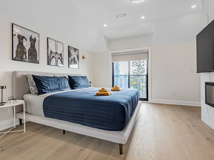 Dormitorio principal Retiro equipado con baño privado, colchón con la parte superior acolchada tamaño king, TV de 65pulgadas y chimenea para un entorno cálido y acogedor.