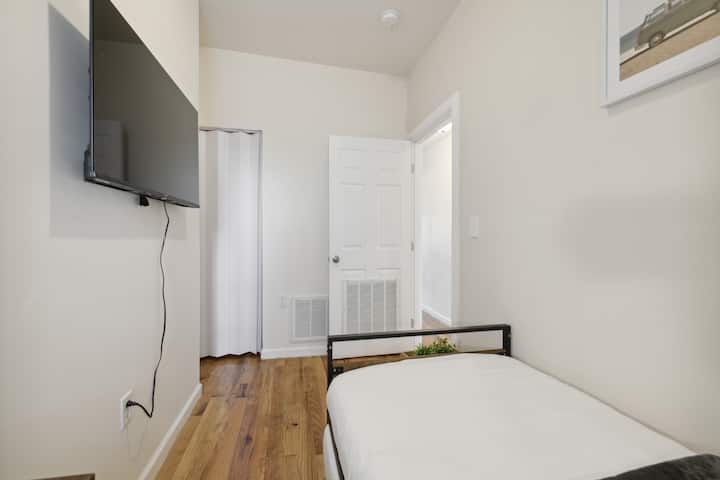 舒适的第二间卧室，配有衣柜和智能电视。