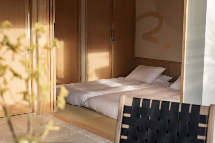 Chumba cha mtindo wa Kijapani (chumba cha Tatami)
Ni sehemu tulivu iliyopambwa kwa sanaa ya karatasi ya Kijapani ukutani.
Tutakupa mito ya shanga na mito yenye harufu nzuri, kwa hivyo ni sehemu ambayo itaponya uchovu wa safari yako.
Inawezekana kuweka futoni kwa hadi watu watatu na mlango unaoteleza uliotengenezwa kwa mianzi unaweza kulindwa kwa faragha, na kuifanya ifae kwa marafiki na kukaa na kaya 2 au 3.