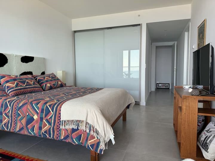 חדר שינה ראשי צמוד עם מרפסת ונוף לים, מיטה זוגית נוחה, מקום וטלוויזיה