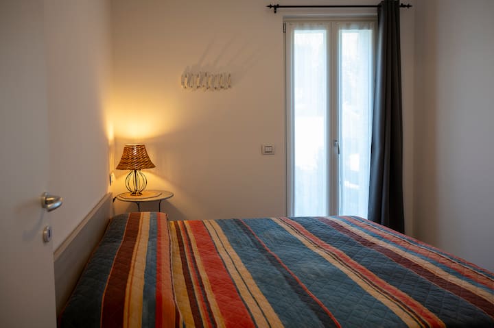 Svijetla dvokrevetna soba s udobnim krevetom i nježnim osvjetljenjem koja stvara opuštajuću atmosferu za miran san. Velika stijena s prozorima omogućuje ulazak prirodnog svjetla i svježeg zraka tijekom dana.
