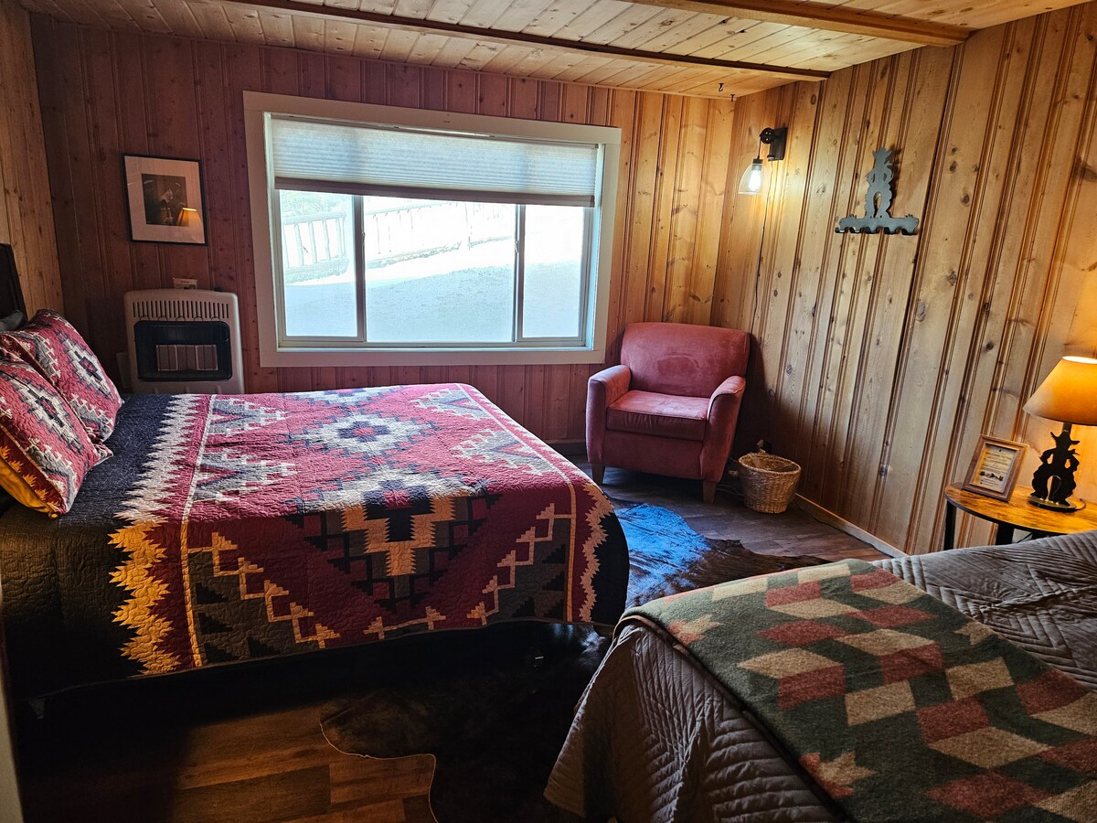 La habitación de la cabaña Yale ofrece una cama queen y una cama individual.