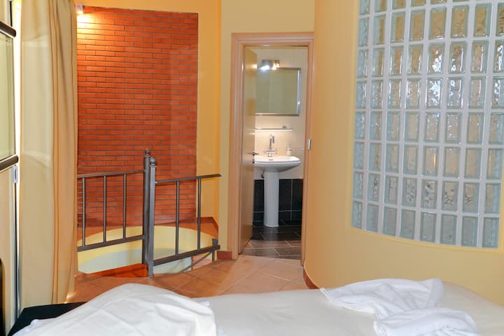 Suita kryesore e katit të dytë me krevat dopio "queen", banjë e plotë me jacuzzi dhe dy ballkone private