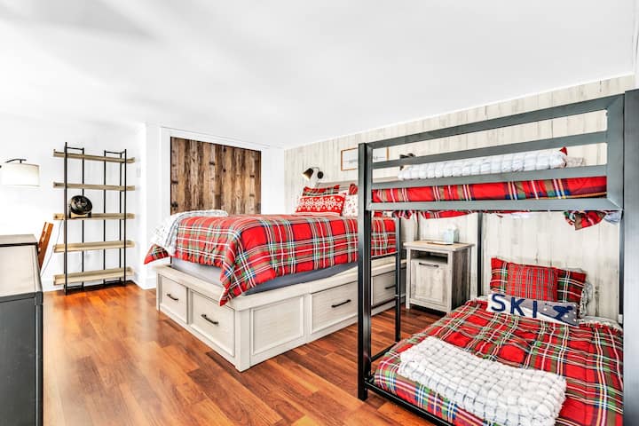 במעלה המדרגות לאזור הלופט הגדול עם מיטת קווין סייז, תאום מעל מיטות קומותיים, שולחן/כיסא ומדף ספרים, כמו גם ארון ושידה גדולים.