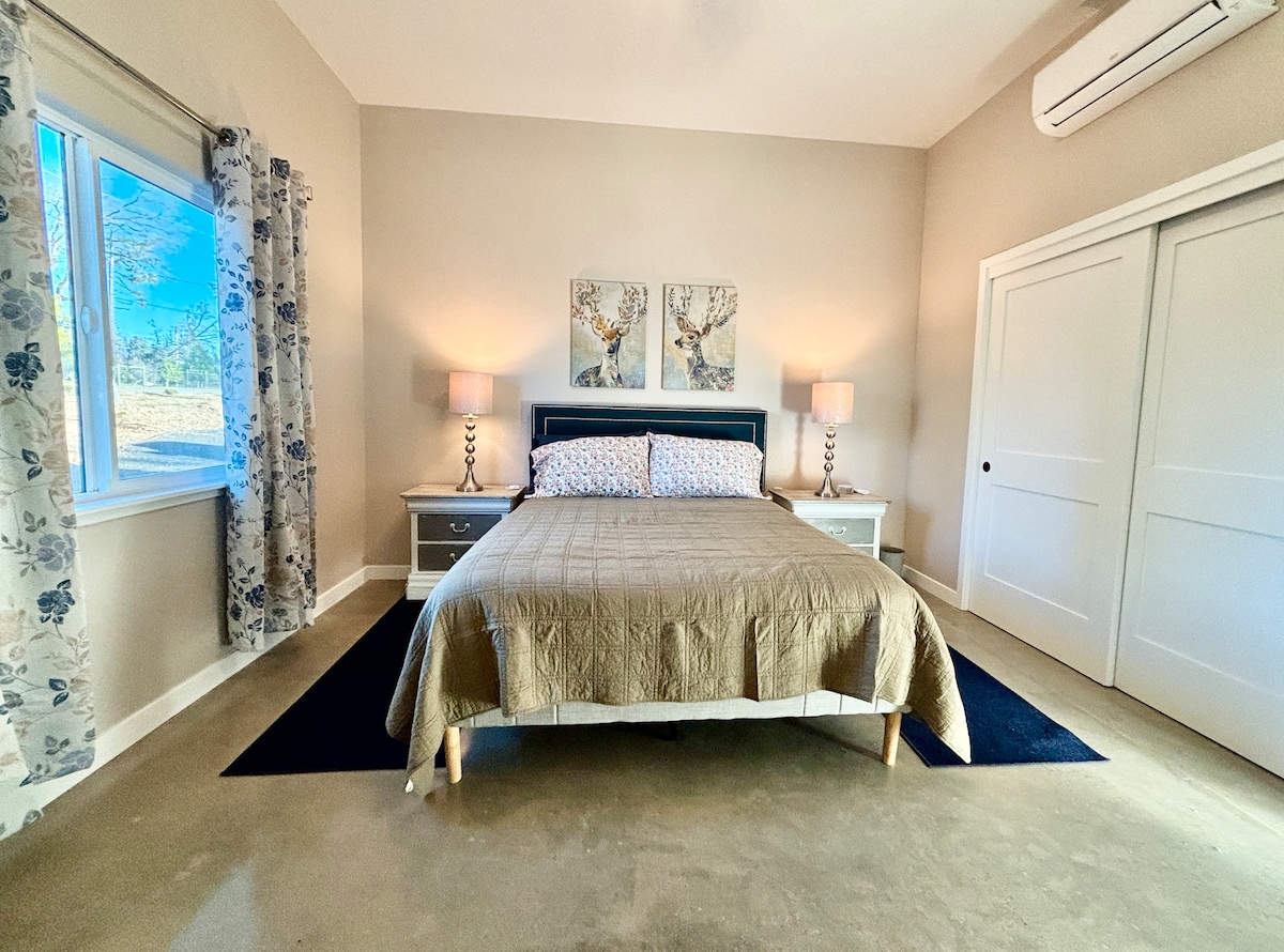 Toegankelijke slaapkamer met laag queensize bed en brede speling