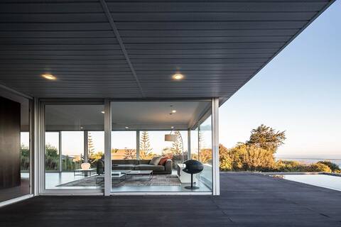 Modern house with ocean views and a large garden.