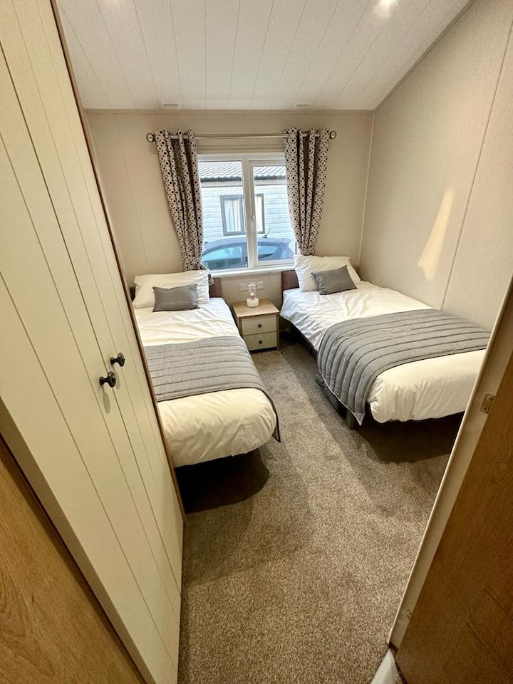 חדר שינה זוגי. כולל 2 מיטות יחיד בגודל מלא. מלתחה וארונית ליד המיטה