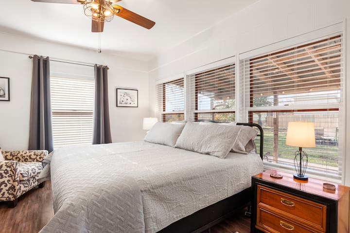 Kitanda laini na chenye vyumba vingi kinapendeza chumba cha kulala cha kwanza hapa, chenye madirisha makubwa ambayo yanakaribisha mwanga wa asili ndani ya chumba.