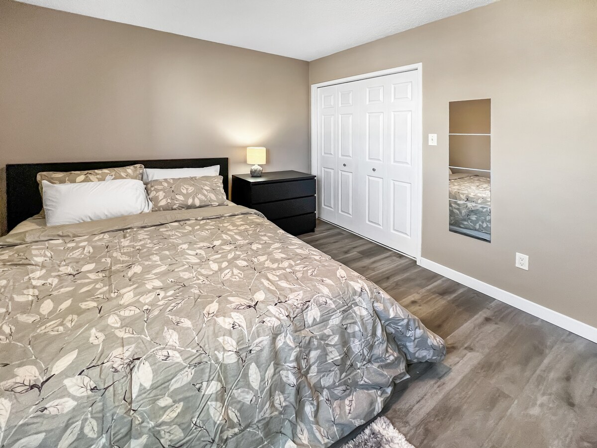 Топла и светла пространа спална соба со основни гардеробери, пегла и преносна греалка.