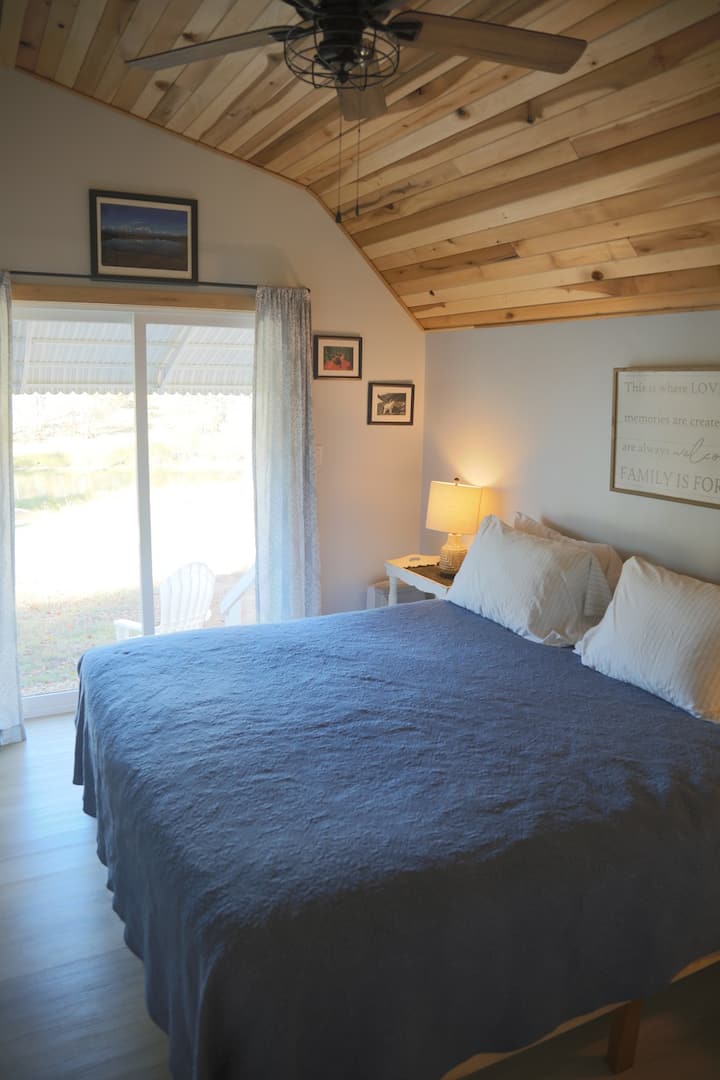 Relax and unwind in the king-size bed, enjoying a picturesque view overlooking the lake for a tranquil and comfortable retreat.