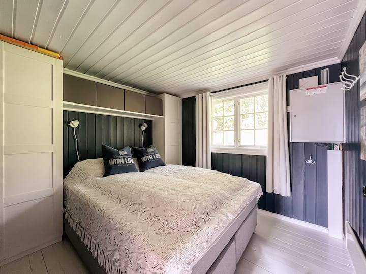 Dormitorio con cama matrimonial y horno de panel.