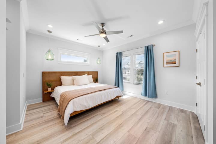 Hlavná spálňa zahŕňa manželskú posteľ King, závesné osvetlenie a pripojenú vaňu a sprchu.